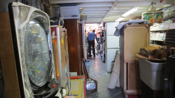 Swenson rearranges furniture to clear the narrow passage way. 